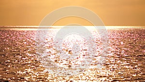 Abstract sea summer ocean sunset nature background. Sound of small waves on golden water surface in motion blur with