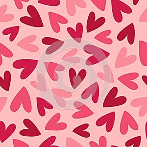 Abstract seamless pattern with pink and red hearts on pink background. Hand drawn doodle style. Great for