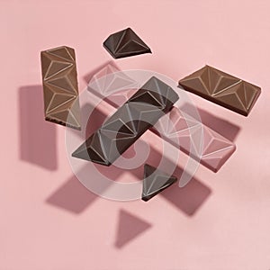 Abstract set of levitation colored chocolate on a pink background. Flying chocolate casts shadows