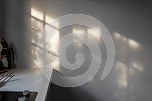 Abstract shadow background of leaves and window from sunlight on white wall at kitchen