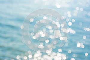 Abstract shining sunlight bokeh on blue sea water texture background.