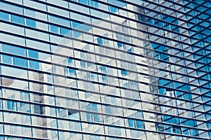Abstract shot of glass transparent skyscraper office building for texture or background. Blue toned.
