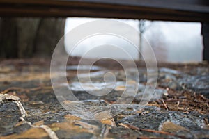 Abstract shot of wet flagstones under a park bench photo