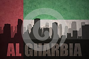 Abstract silhouette of the city with text Al Gharbia at the vintage united arab emirates flag