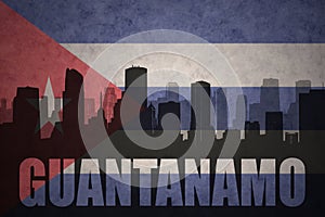 Abstract silhouette of the city with text Guantanamo at the vintage cuban flag