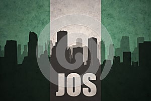 Abstract silhouette of the city with text Jos at the vintage nigerian flag