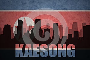 Abstract silhouette of the city with text Kaesong at the vintage north korea flag