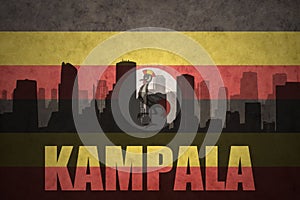 Abstract silhouette of the city with text Kampala at the vintage ugandan flag