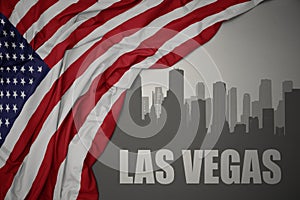 Abstract silhouette of the city with text las vegas near waving national flag of united states of america on a gray background