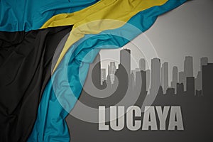 Abstract silhouette of the city with text Lucaya near waving national flag of bahamas on a gray background. 3D illustration