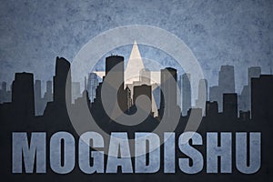 Abstract silhouette of the city with text Mogadishu at the vintage somalia flag photo