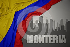 Abstract silhouette of the city with text Monteria near waving national flag of colombia on a gray background photo