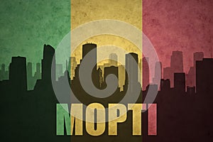 Abstract silhouette of the city with text Mopti at the vintage malian flag