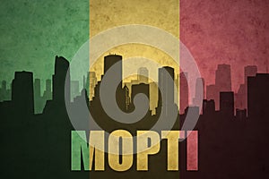 Abstract silhouette of the city with text Mopti at the vintage malian flag photo