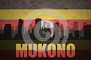 Abstract silhouette of the city with text Mukono at the vintage ugandan flag