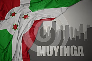 Abstract silhouette of the city with text Muyinga near waving colorful national flag of burundi on a gray background