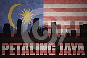 Abstract silhouette of the city with text Petaling Jaya at the vintage malaysian flag