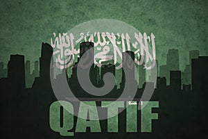 Abstract silhouette of the city with text Qatif at the vintage saudi arabia flag photo