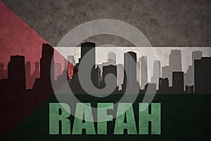 Abstract silhouette of the city with text Rafah at the vintage palestinian flag