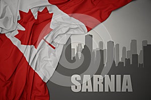 Abstract silhouette of the city with text Sarnia near waving national flag of canada on a gray background photo