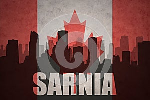 Abstract silhouette of the city with text Sarnia at the vintage canadian flag photo