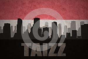 Abstract silhouette of the city with text Taizz at the vintage yemen flag