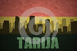 Abstract silhouette of the city with text Tarija at the vintage bolivian flag photo