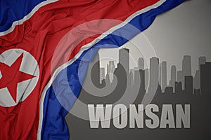 Abstract silhouette of the city with text Wonsan near waving national flag of north korea on a gray background.3D illustration