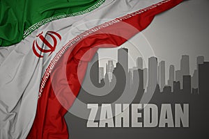 Abstract silhouette of the city with text Zahedan near waving national flag of iran on a gray background.3D illustration photo