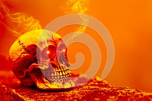 Abstract skull in orange tone with eye shining light and smoke.