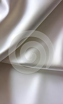 Abstract smooth elegant white fabric silk texture soft background, flowing satin waves. Gray, silver fabric silk texture close up.