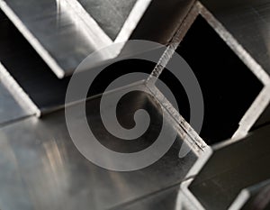 Abstract stack of aluminium profiles close up, industrial background macro