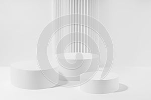 Abstract stage with three white round podiums with striped pillar as decoration, mockup on white background