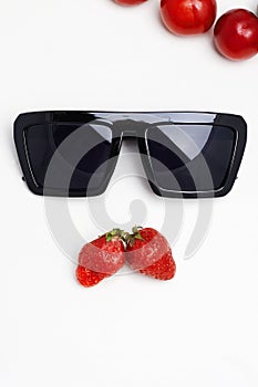 Abstract still life. sunglasses and berries like a male face