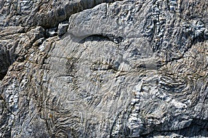 Abstract stone background - black, grey, dark stone texture - folded rocks