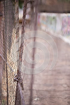 An abstract style shot of shoddy wire mesh fencing and gates wit