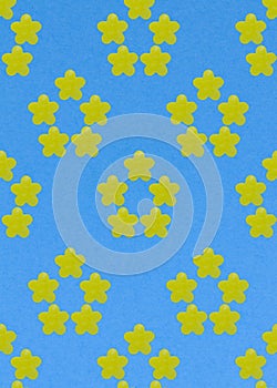 Abstract summer flower made of yellow candy on a blue background