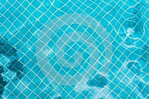 Abstract swimming pool bottom caustics ripple and flow with waves background. Summer background. Texture of water surface.