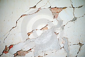 Abstract texture and background of broken plastered cement wall with red bricklayers inside