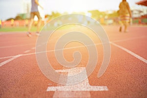 Abstract texture and background of empty running track with number one on the floor in foreground and defocused people exercising