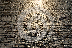 Abstract texture, background of sunlit road cobbles