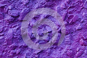 Abstract texture of concrete wall covered uneven decorative stucco and painted bluish-purple paint