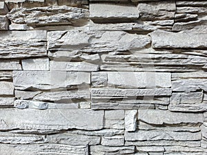 Abstract texture of gray stone facing on the wall of the building. Gray stone background. Selective focus