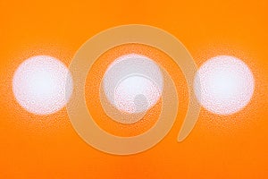 Abstract texture of multiple water drops on orange background with three white circles