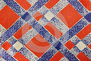 Abstract texture of red cotton fabric with diagonal blue lines. Natural fabric background