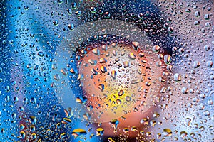 Abstract texture. Water drops on glass with lamp background
