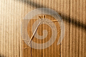Abstract texture of a wrinkled cellotape on a brown cardboard box carton