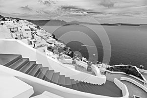 Abstract travel landscape, black and white view of Oia Santorini Greece. Cloudy sky and dark sea bay. Monochrome edit