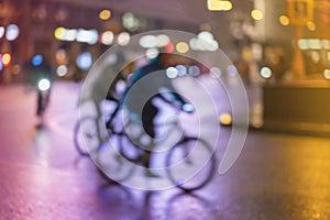 Abstract unrecognizable people, riding bikes, night city, illumination bokeh, motion blur. Healthy lifestyle, leisure