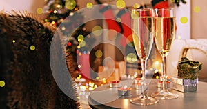 Abstract vector illustration of champagne glasses and gifts on table in living room photo